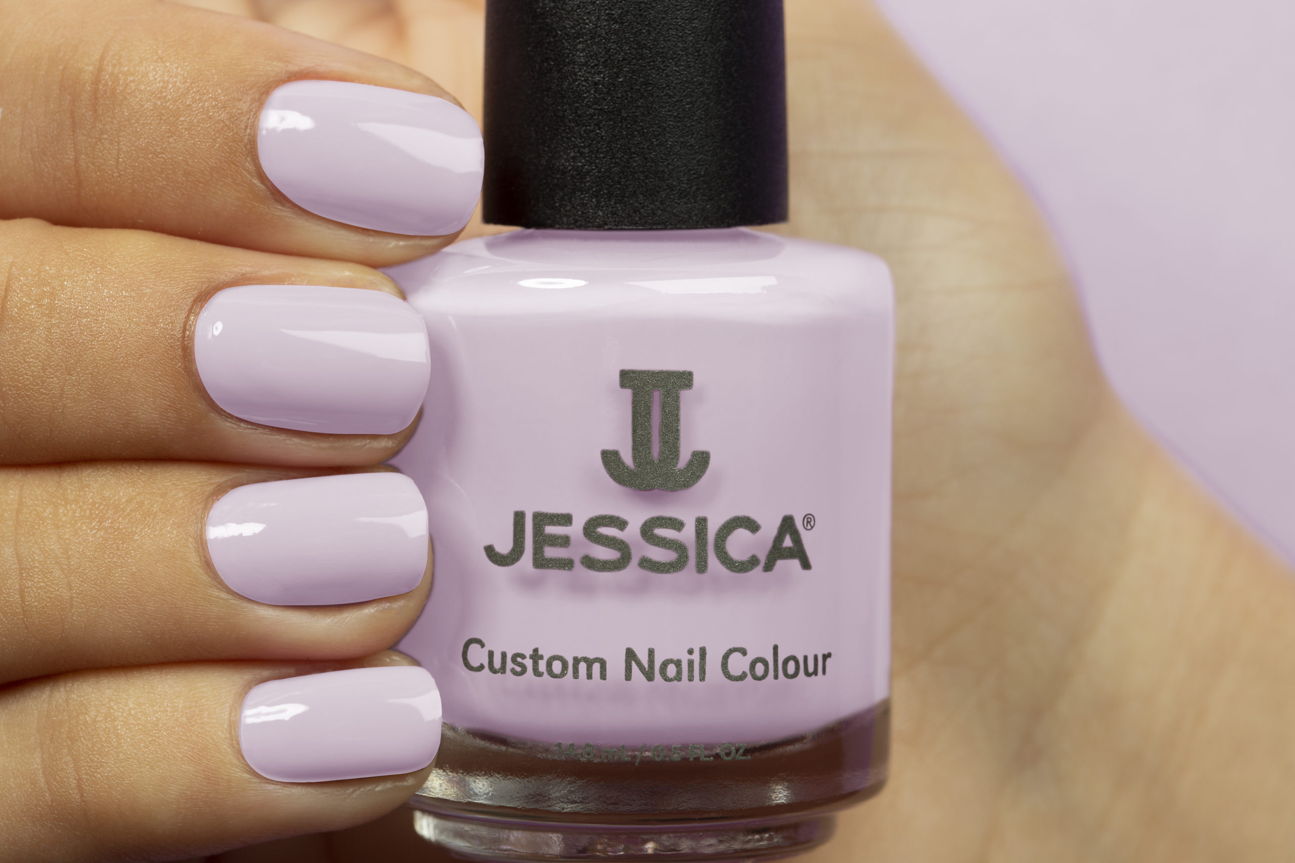 Manicured hands wearing and holding Lavender Love Custom Colour Nail Polish
