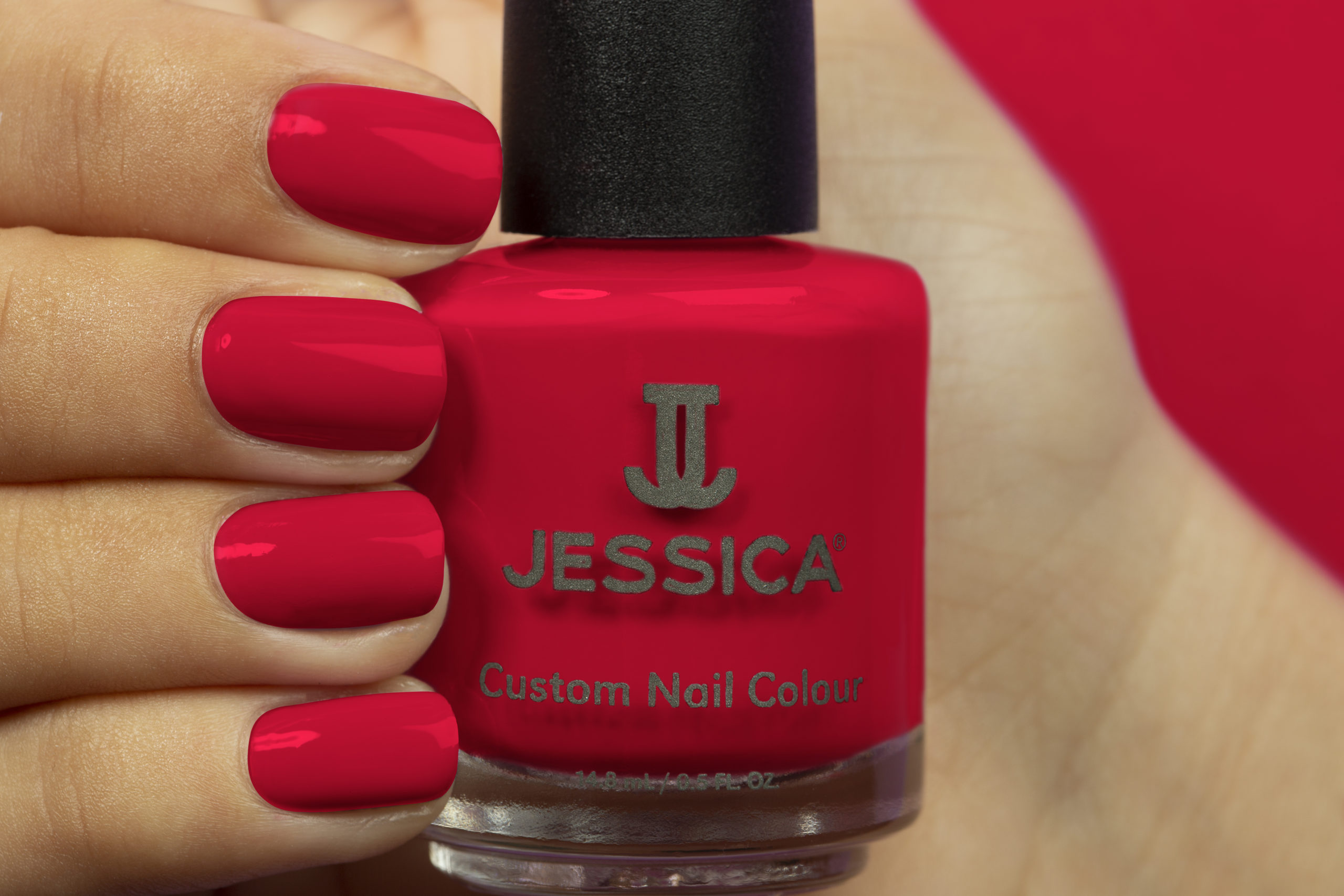 Manicured hands wearing and holding Royal Red Custom Colour Nail Polish