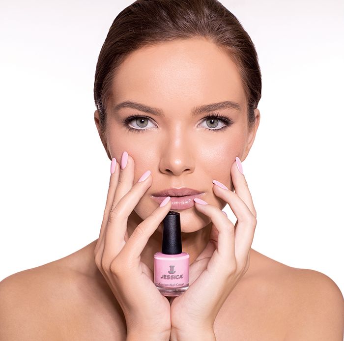 Model with pink manicured nails holding a pink Custom Colour Nail Polish