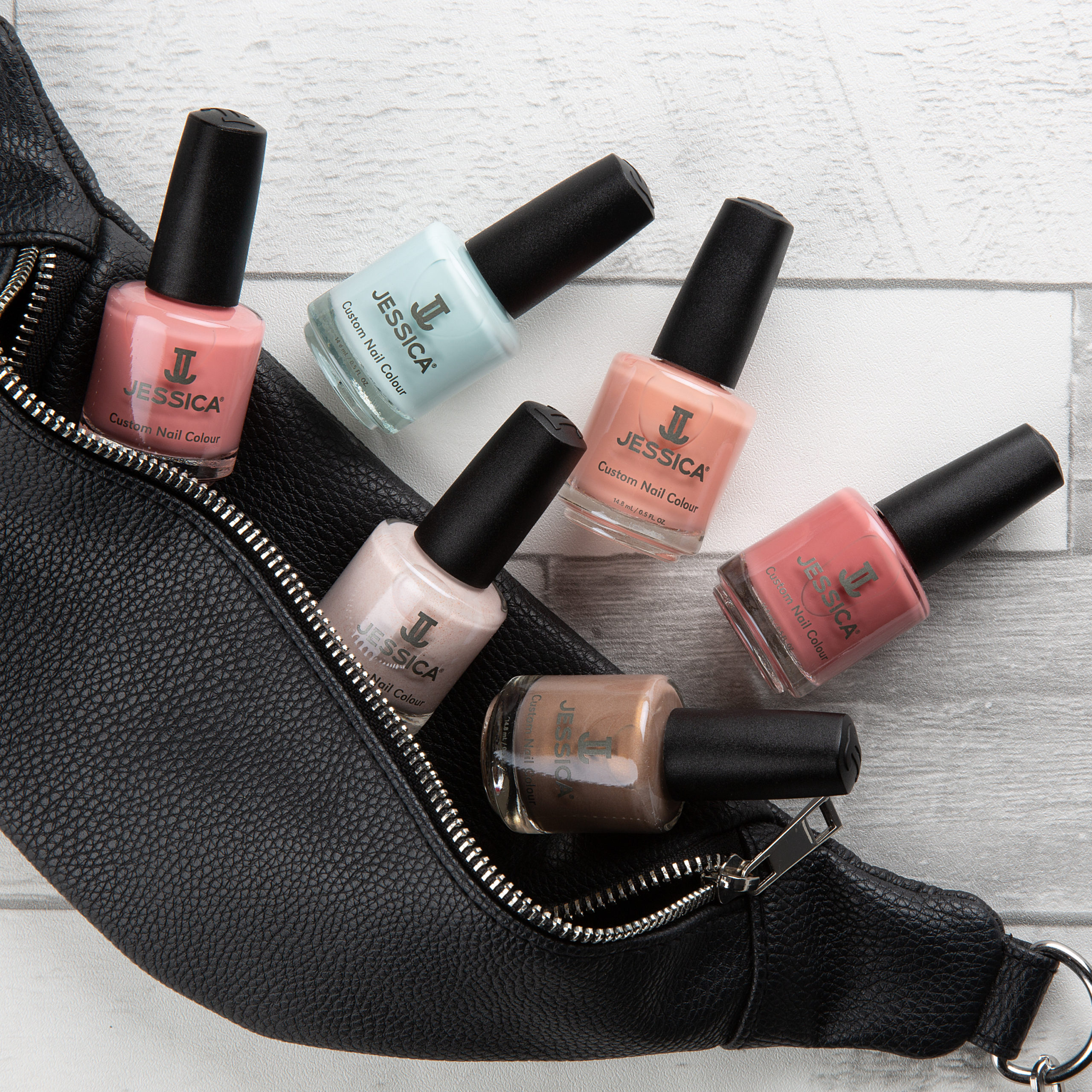 JESSICA Spring Nail Polishes dropping off a black leather bag